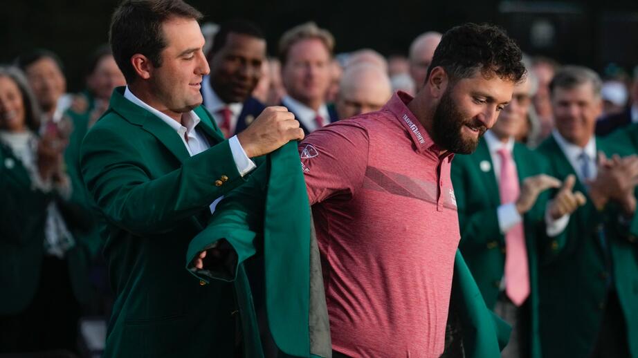 Förra årets vinnare Jon Rahm tar emot sin gröna kavaj från vinnaren 2022.
