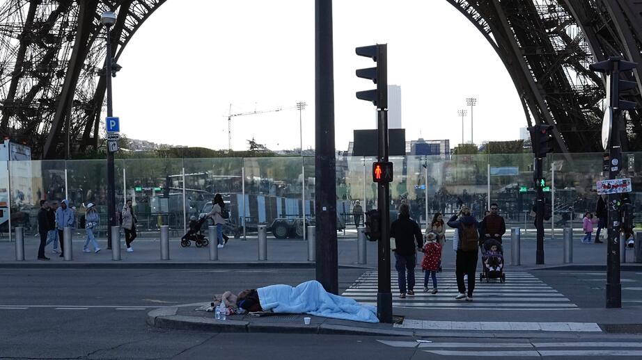 En hemlös vid Eiffeltornet i Paris. Arkivbild. 