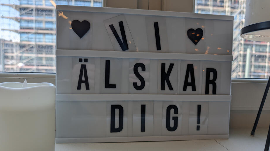 I fönstret bakom soffan står en skylt med ett viktigt budskap