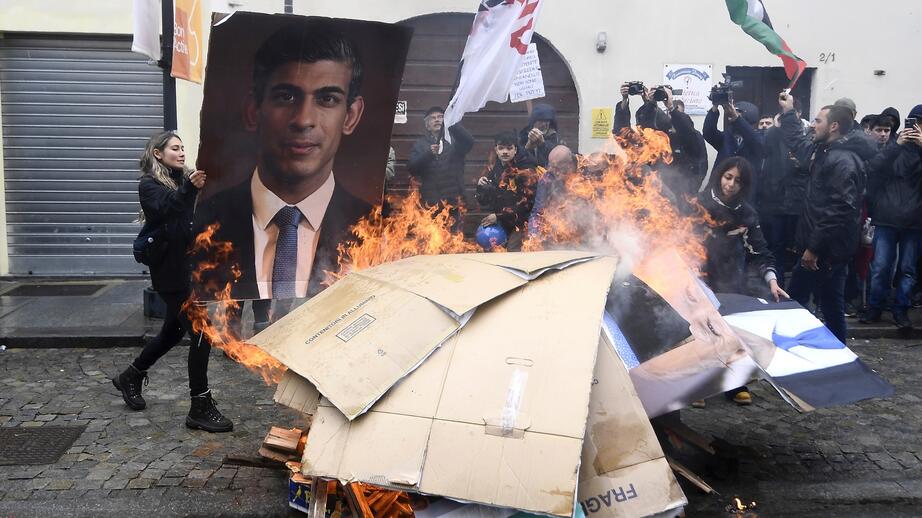 En bild på Rishi Sunak, Storbritanniens premiärminister, eldas upp av demonstranterna.