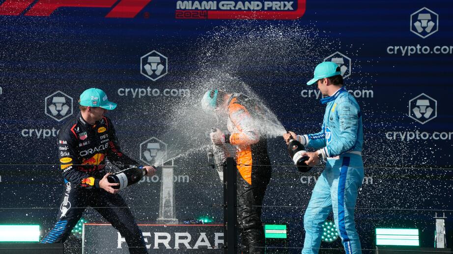 Lando Norris blir nersprutat av sina medtävlande Leclerc och Verstappen.