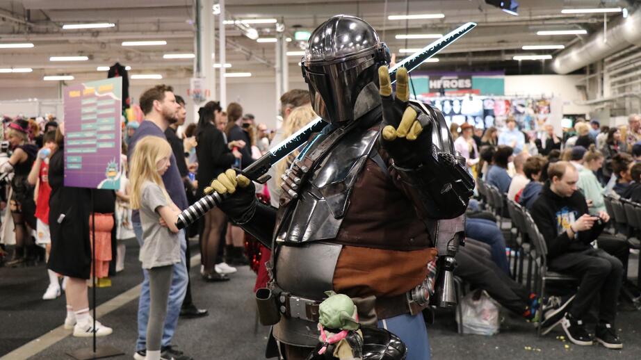 The Mandalorian (Din Djarin) med Baby Yoda tätt intill. 