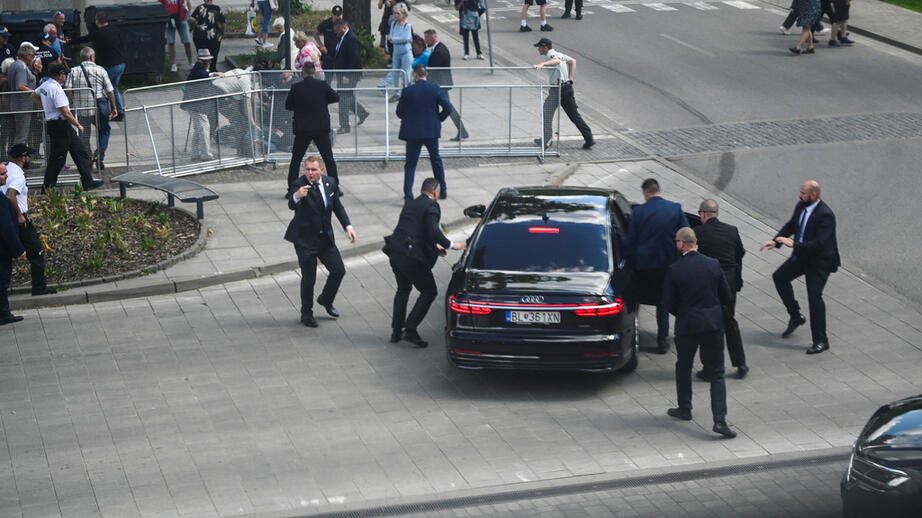 Robert Fico får hjälp in i en bil efter att ha blivit skjuten.
