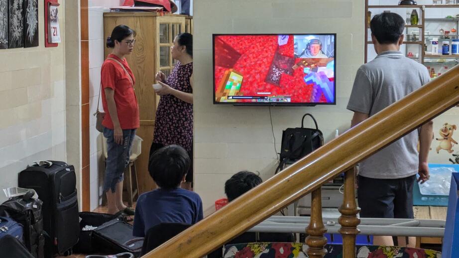 Barnen tittar på en Minecraft-livestream medan de vuxna pratar i köket.