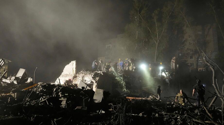 Räddningspersonal letar i rasmassorna i Kiev.