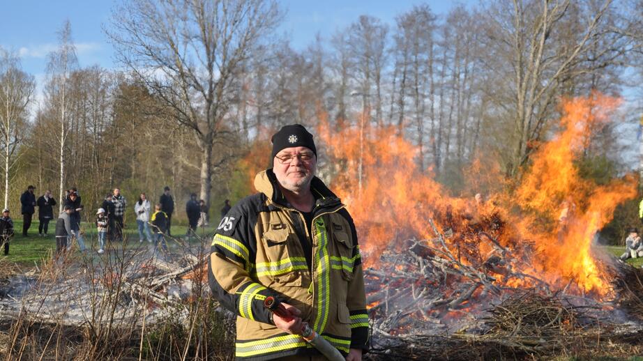 Tommy Norén vaktar brasan. Till sin hjälp har han vattenslangen.