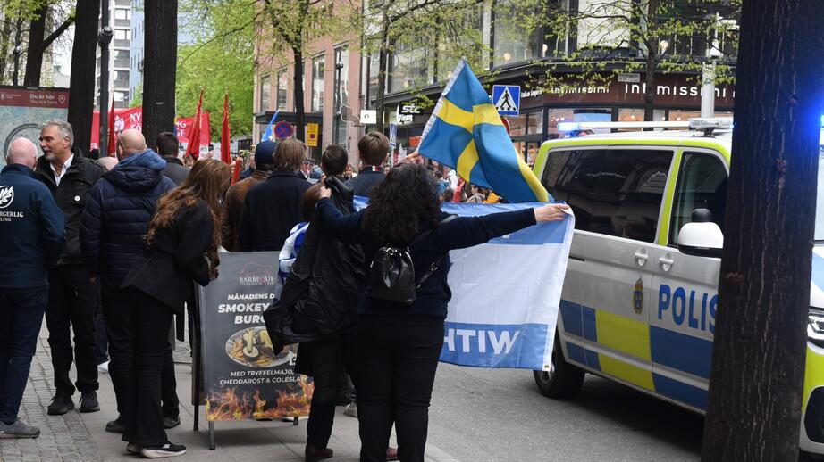 En kvinna håller demonstrativt den israeliska flaggan mot tåget.
