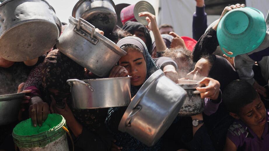 Palestinier som desperat hämtar mat i ett soppkök i Khan Younis, Gaza.