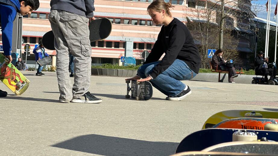 Alice Tande förklarar leken ”singla bräda” på Jan Stenbecks torg i Kista centrum.