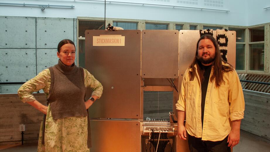 Matilda Norberg och Edvin Nylander framför deras jättestora stickmaskin.