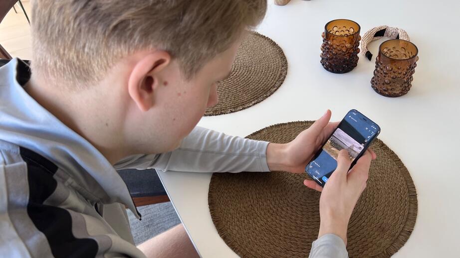 På telefonen visar Gösta ett gruppfoto med sin pluton ute i fält. 
