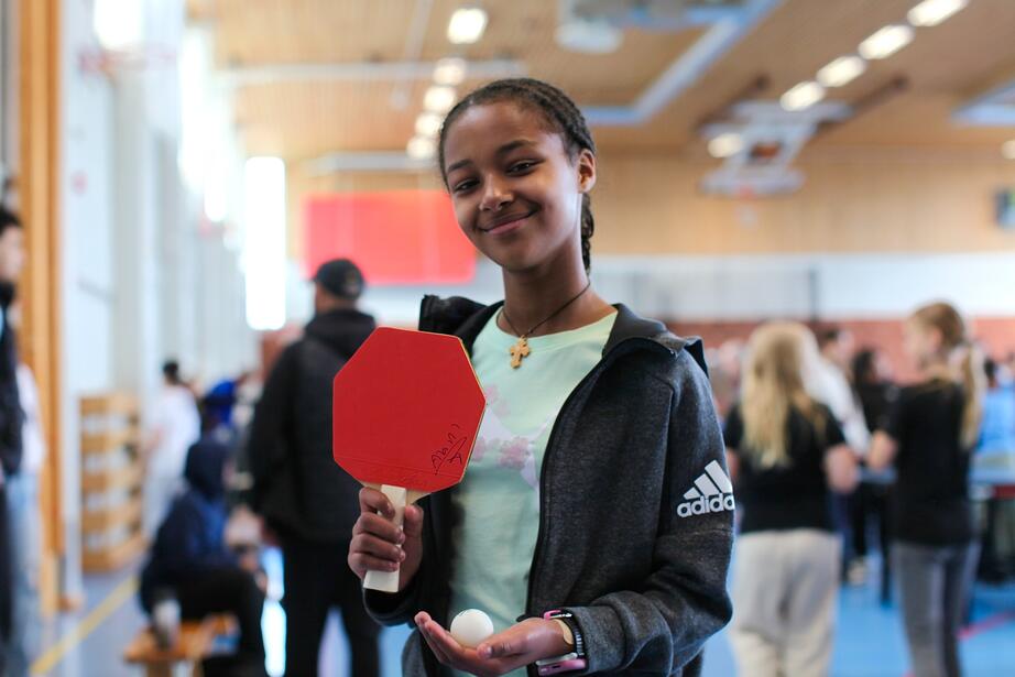 Liya, 11, visar stolt upp Adam Tenstas autograf på sitt pingisracket.