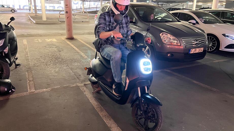 Arvid som parkerar sin elmoped i ett garage på väg till gymmet.